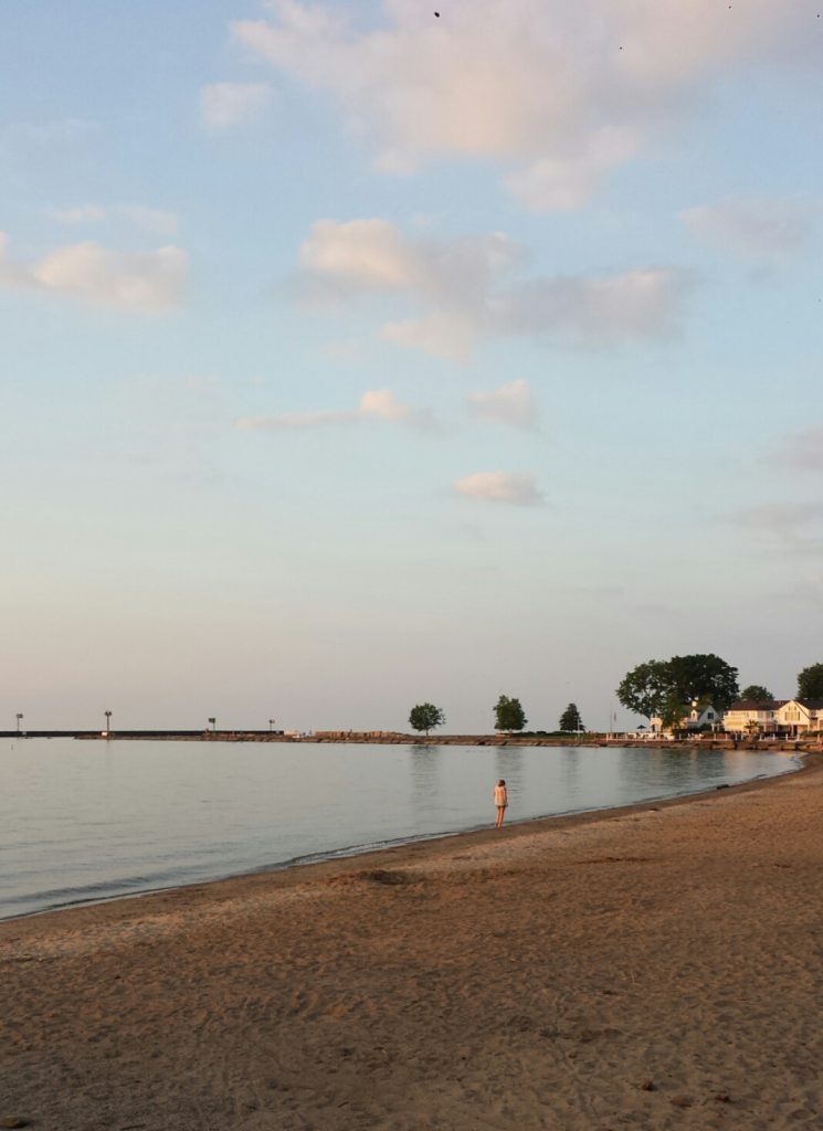 A lake's beach, calm, gladdy water, a blue sky and a tan sandy beach. Yes, there are beaches in Vermilion, Ohio! Read for info about Vermilion, Ohio lodging.