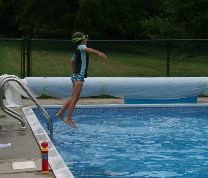 A child jumping into a pool. Summer travel!