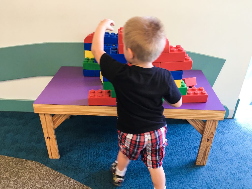 a child playing with larger than normal lego pieces.