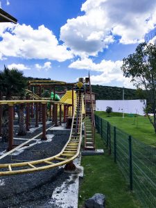 The roller coaster track with the cart nearing the top, ready to roll down the hill. It's small and tame enough for children 