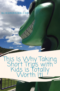 Taking short trips with kids is totally worth it (text over an image of a green dinosaur ride)