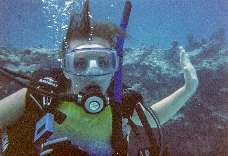 a female scuba diver while diving many feet under the surface of the water.