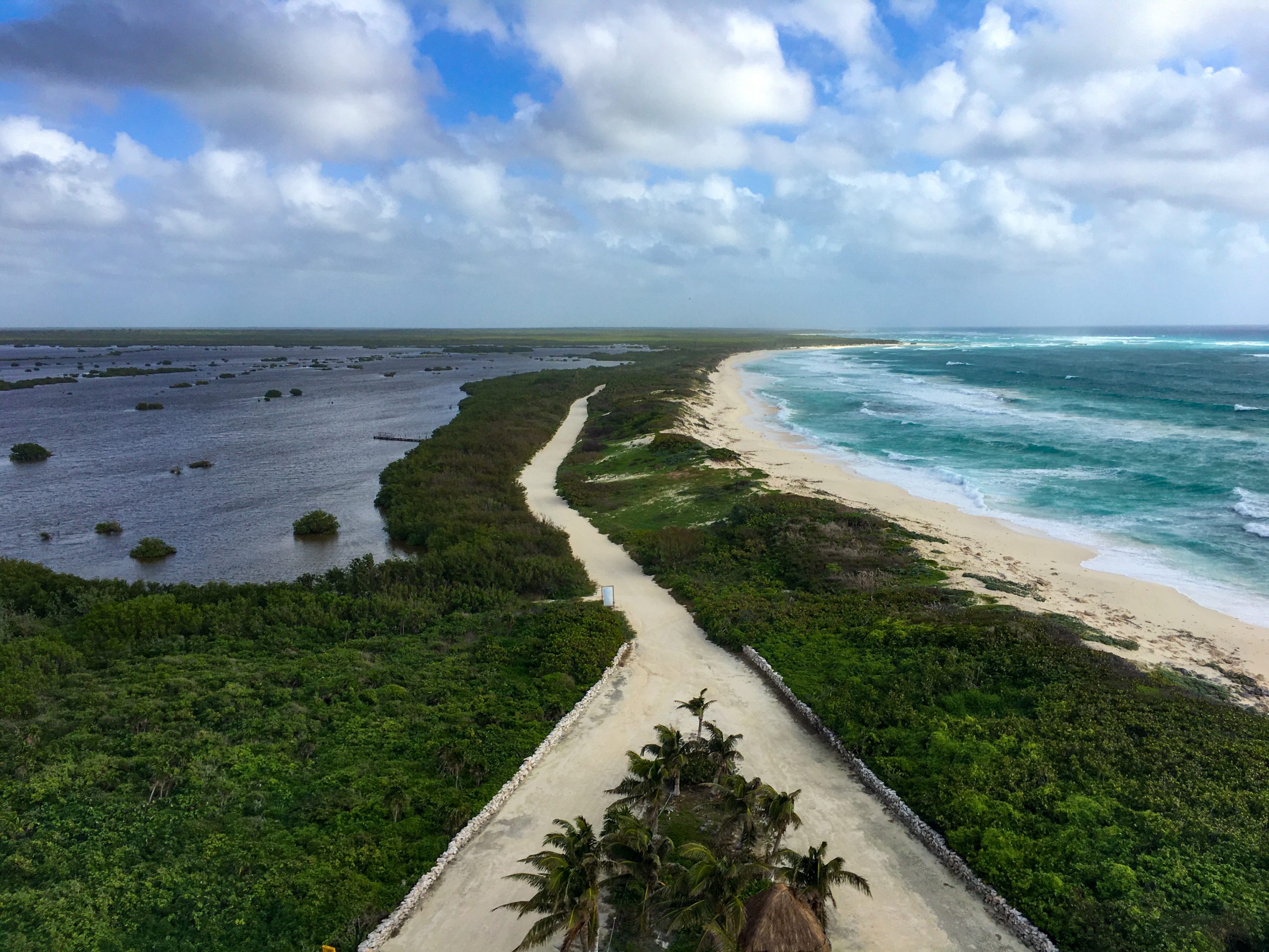 On the left, the lagoons of Punta Sur. On the right, the gorgeous tuquoise ocean. A thing strip of land divides them, with a sand/dirt road.