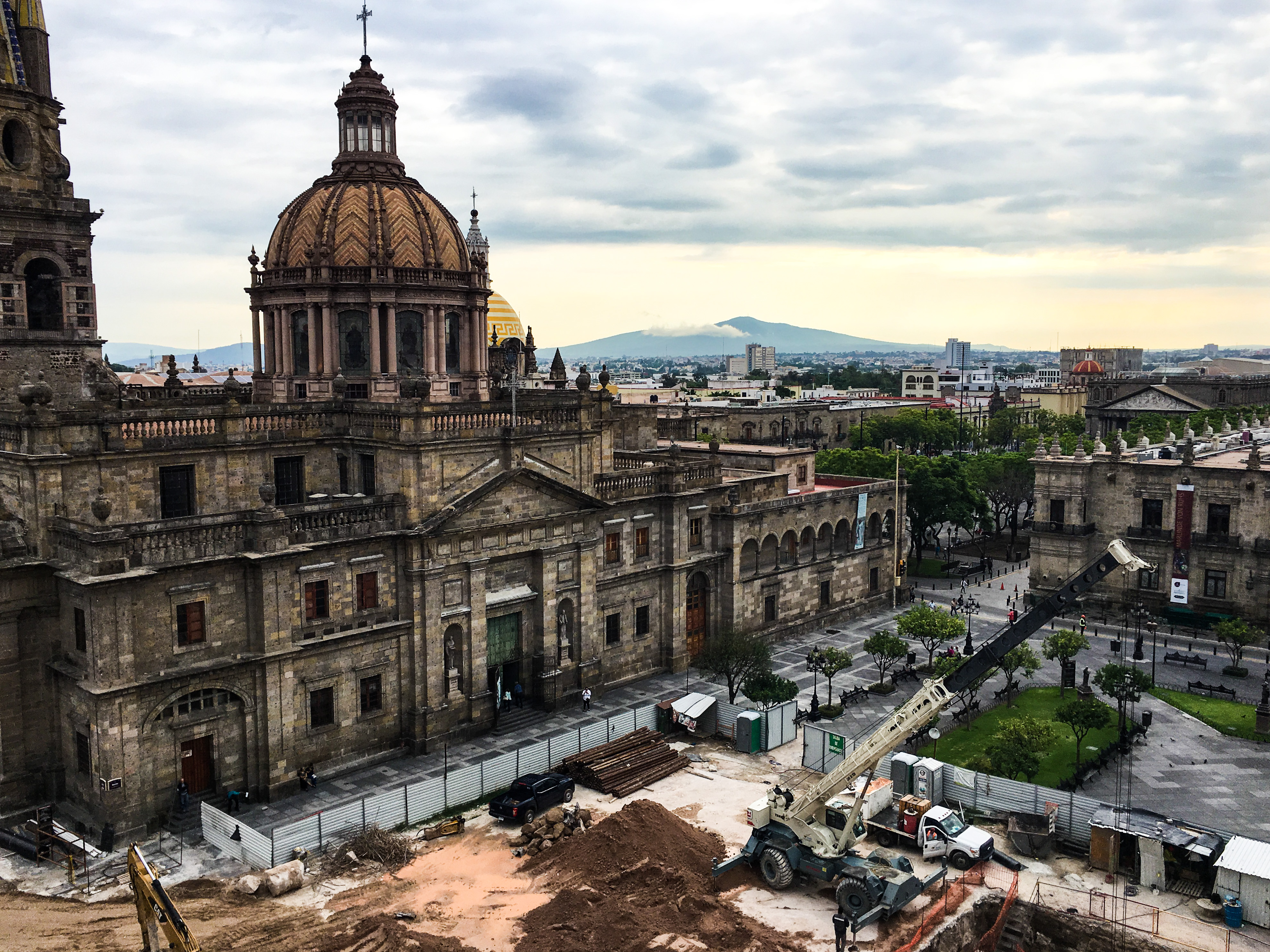 A church with tan and rose hues, visible from the higher floor of our hotel. In front of the church is an area under construction, complete with construction equipment. In things to consider before becoming an expat.