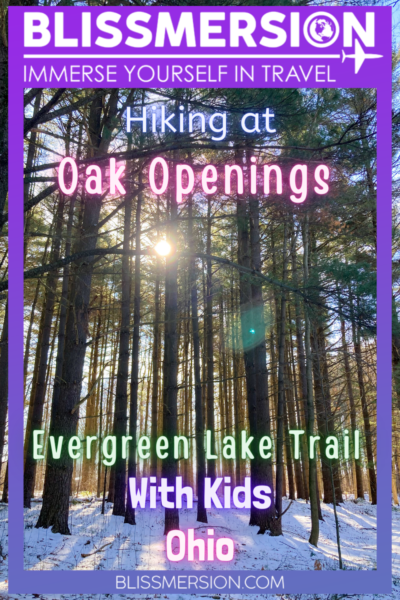 Hiking at Oak Openings Metropark Evergreen Trail with Kids Ohio, text over a photos of tall evergreen trees, with the sun poking through about 1/3 way down the photo.